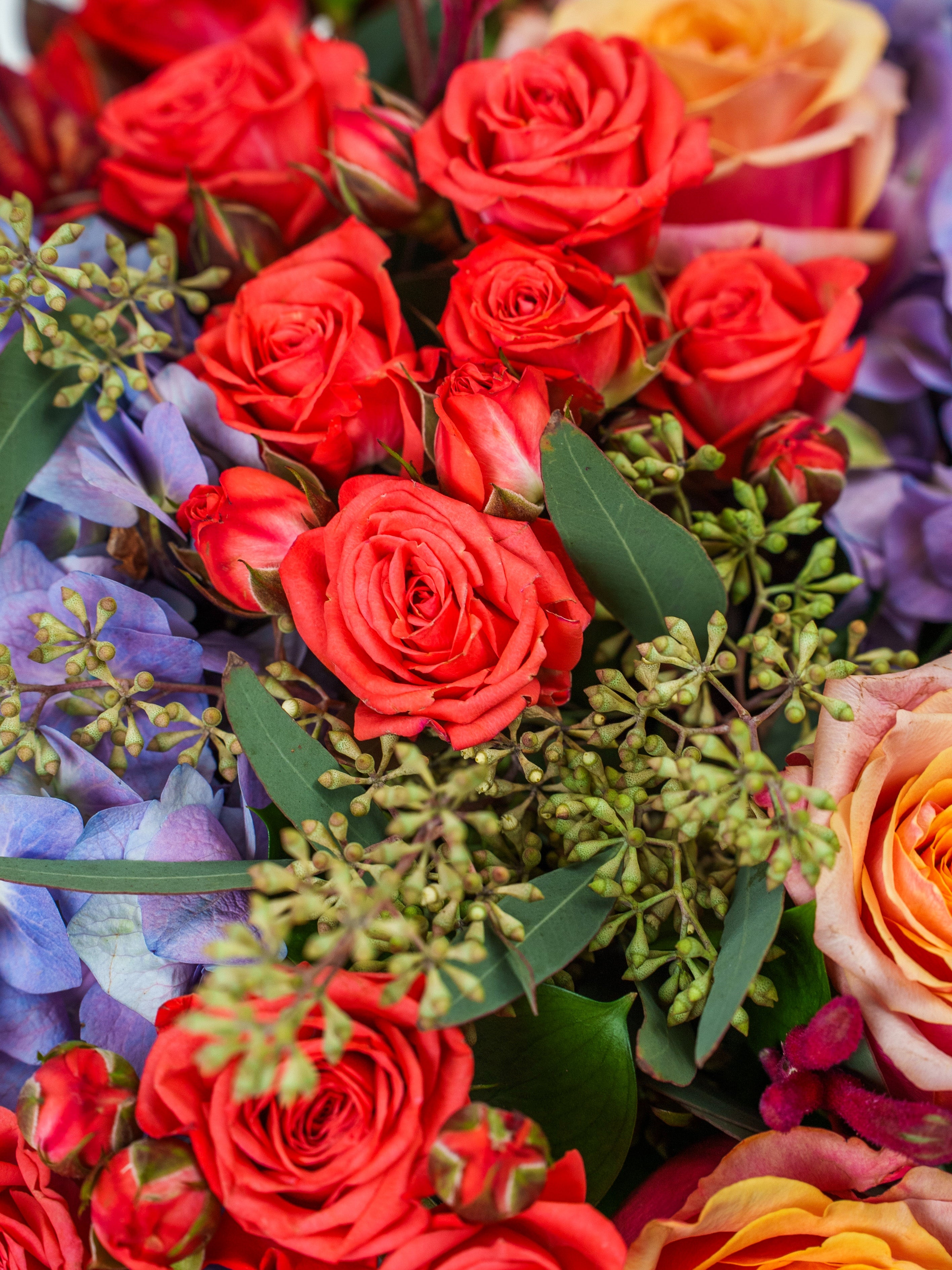 Exotic Sunset bouquet with roses in a vase.