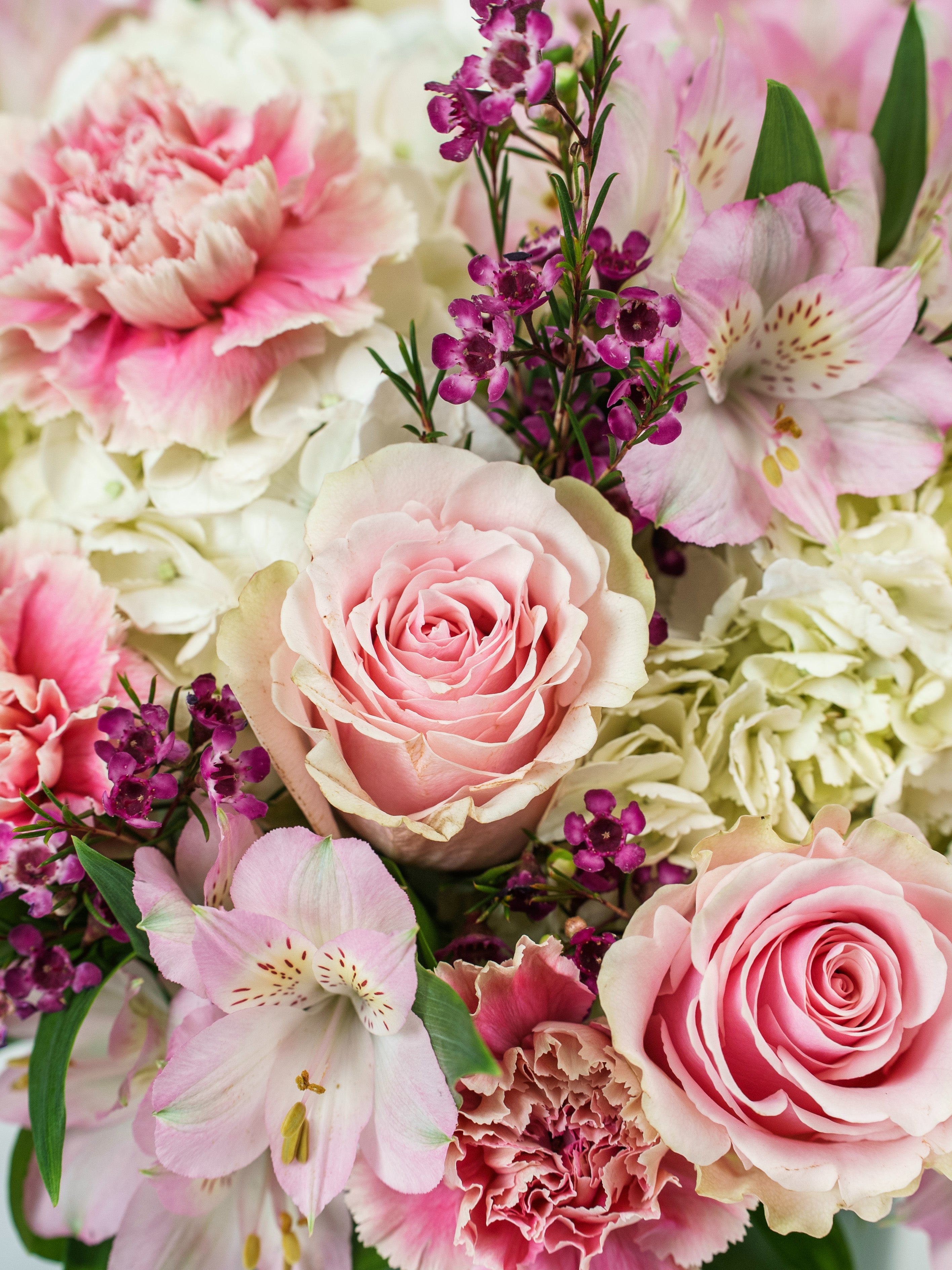Motherly Love bouquet with roses, carnations & alstroemeria in a vase.